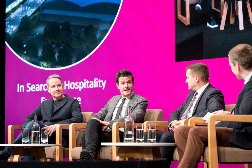 Panel discussion on a pink branded stage at the Annual Hospitality Conference