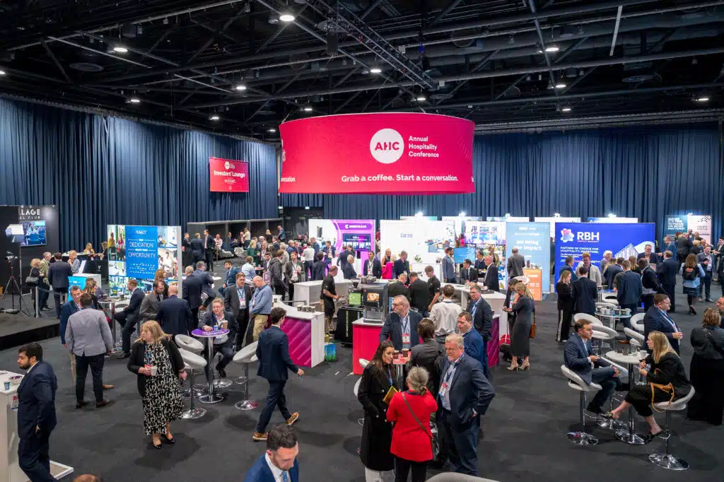 Crowded exhibition floor with branded stands at the Annual Hospitality Conference