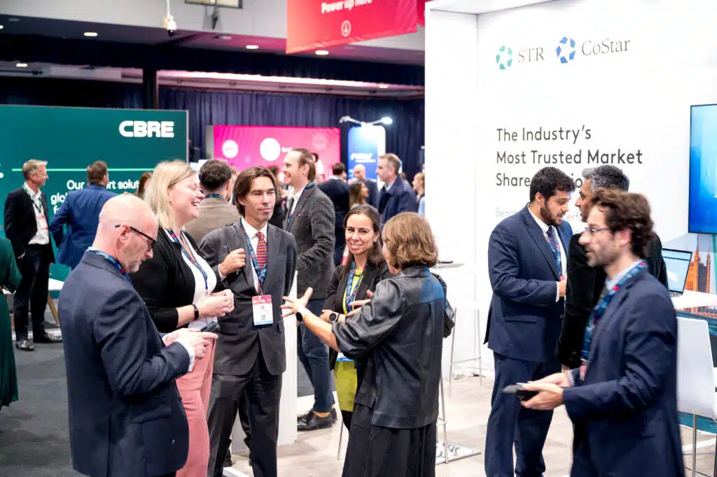 Delegates talking beside a branded stand at the Annual Hospitality Conference