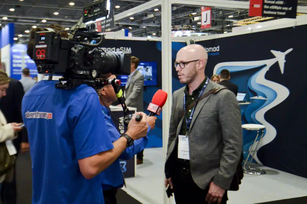 TV interview in front of branded stand graphics at The Business Travel Show