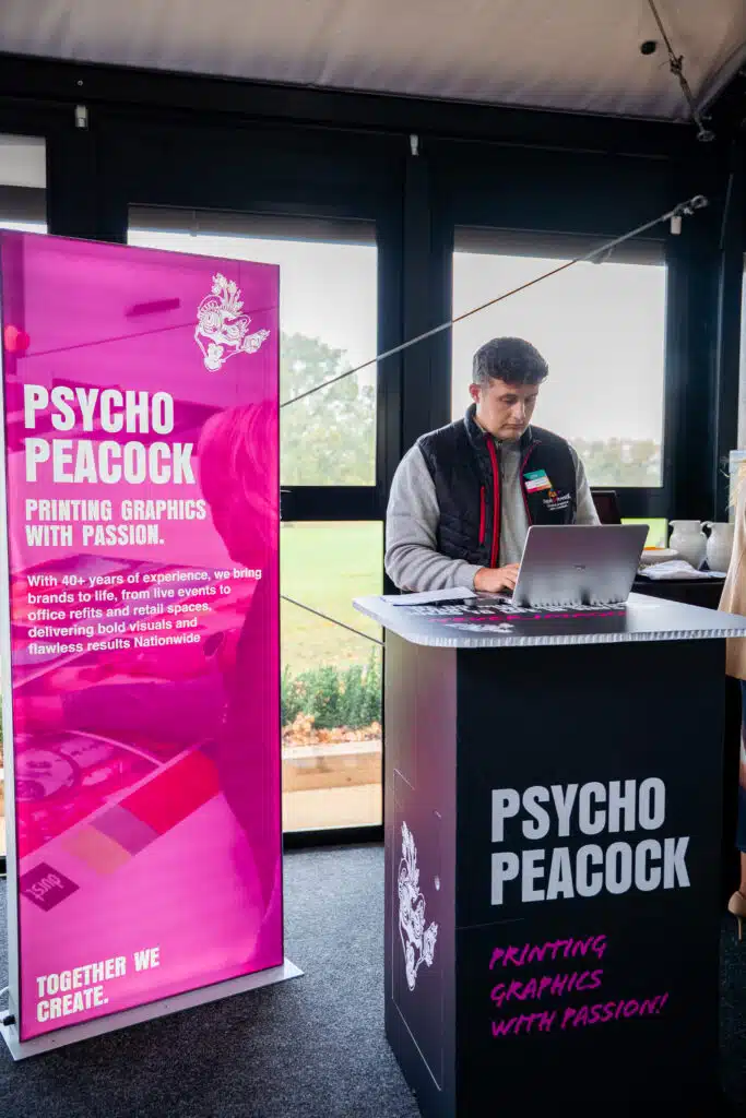 Psycho Peacock branded pull-up banner and counter at the MIA Conference