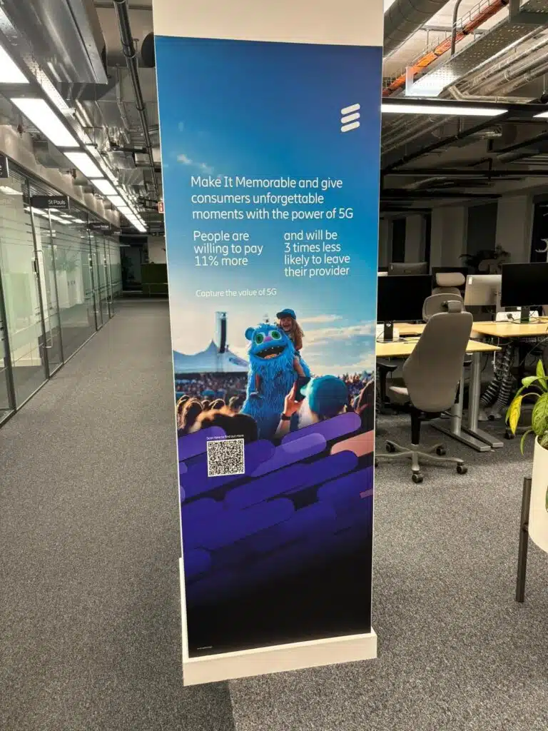 Ericsson branded column wrap graphic in an open-plan office