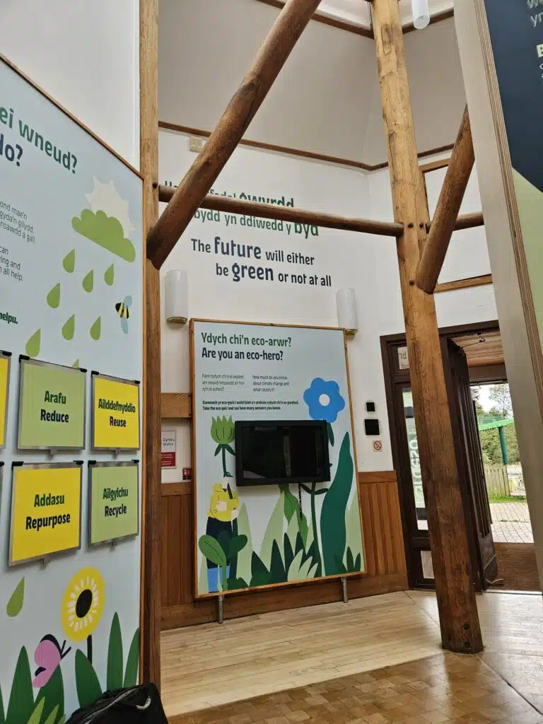 Green illustrated exhibition panels in a timber-framed gallery