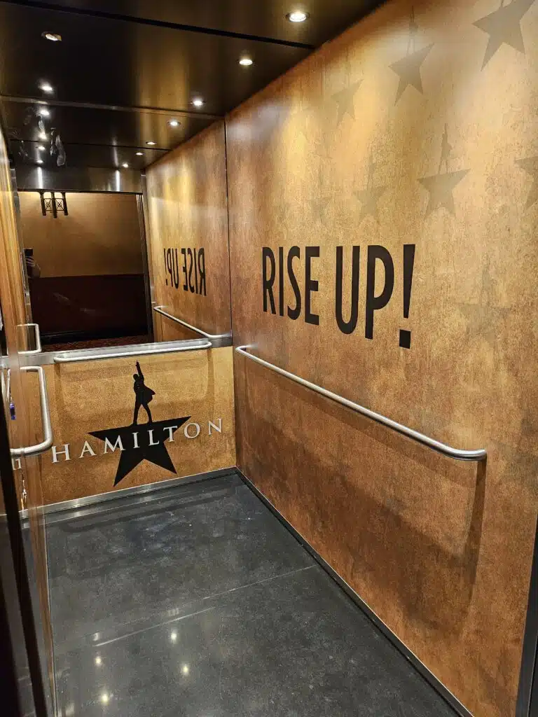 Hamilton 'Rise Up!' wall graphics in a theatre stairwell