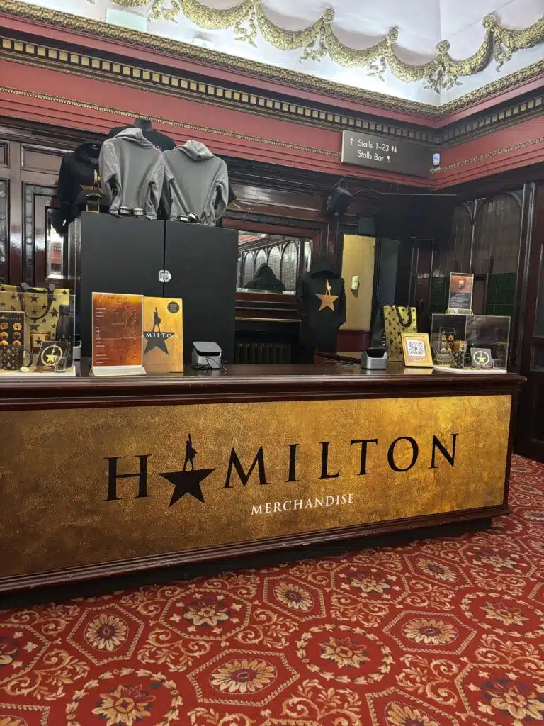 Hamilton merchandise counter with branded graphics in the theatre foyer