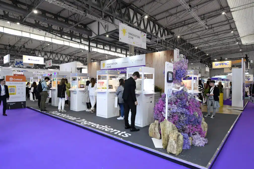 Exhibition stands on a purple floor at In-Cosmetics